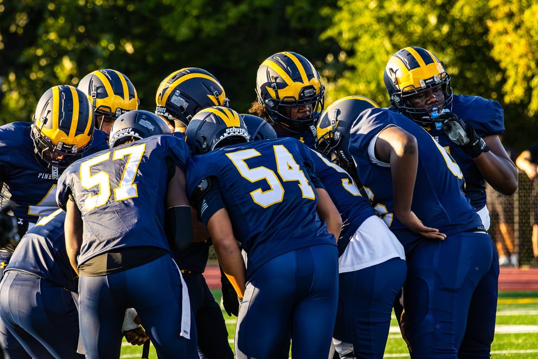 Football: Pine Bush huddles up in the late-day sun against Warwick &mdash; photographed by Chase Plowden for 845 Sports Rewind